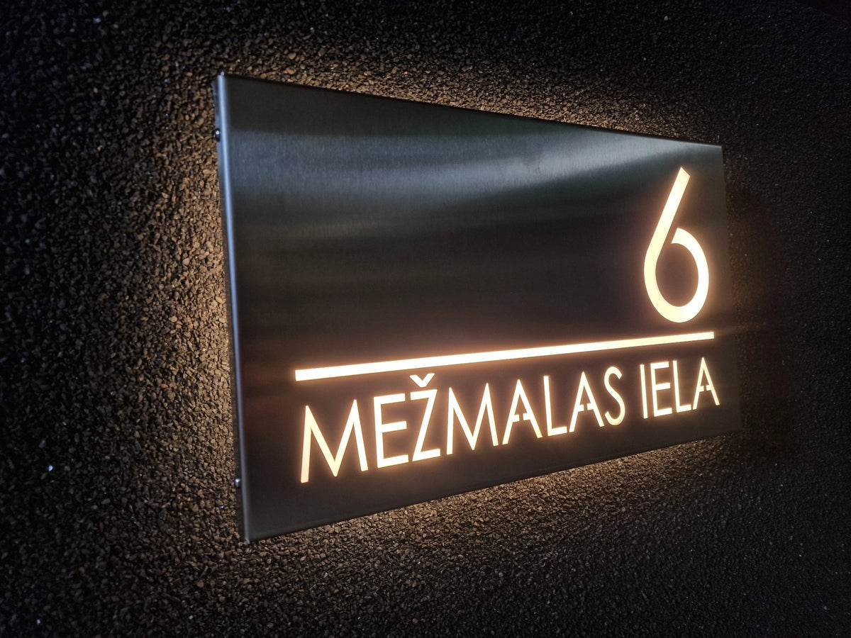 Stainless-steel horizontal LumiSign Horizon with glowing number 6 and street lettering, viewed from the side on a textured rendered wall.
